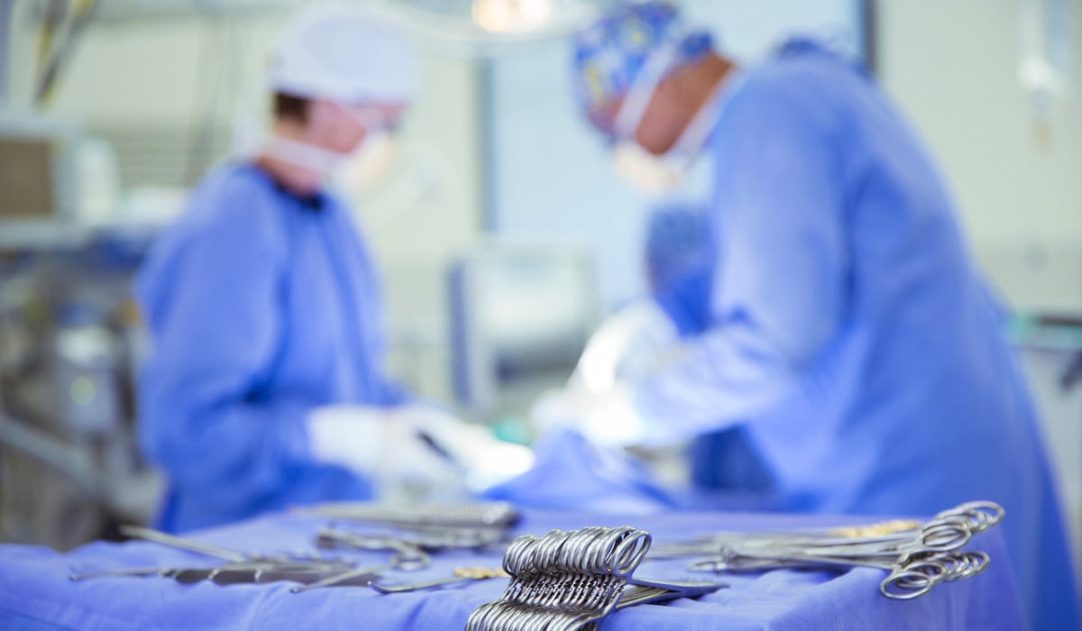 Två kirurger i en operationssal med kirurgisk utrustning.