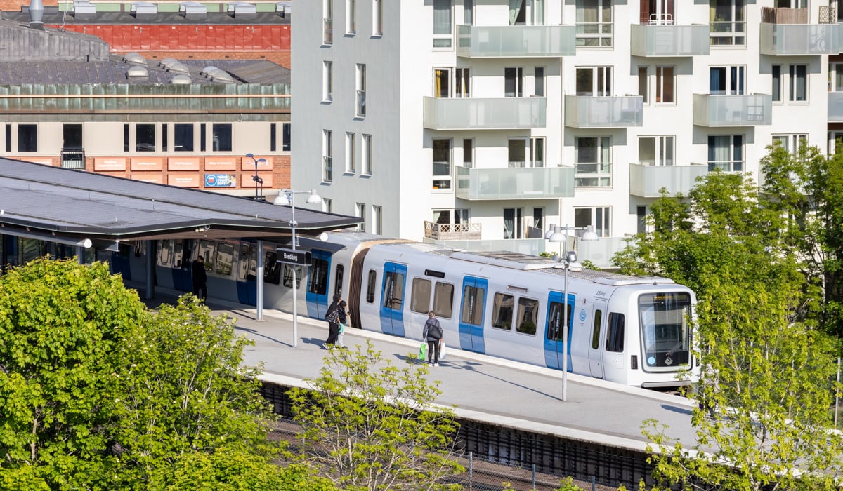 En vitt och blått tunnelbana som rullar ut från perrongen.